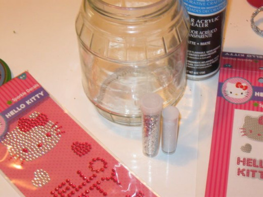 Glue, Mod Podge, spray acrylic or even hair spray could be used to glitter coat the inside of the glass.