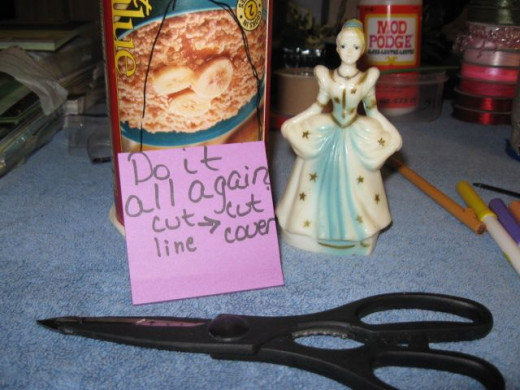 Get your second tower stack, the oatmeal box. Cut out the opening. Make sure it is big enough for your doll to stand in the doorway.