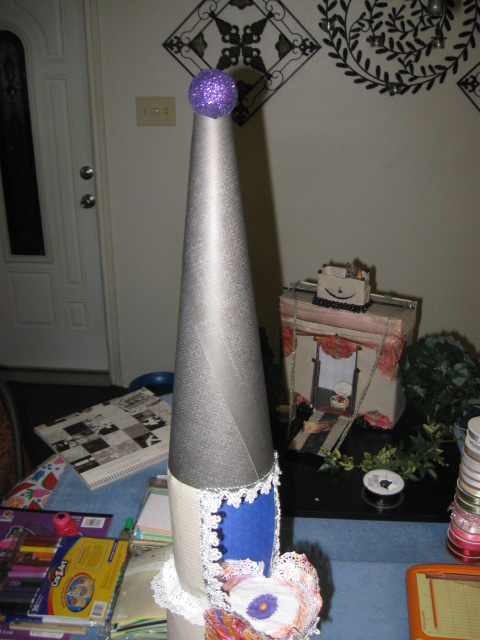 I thought the pattern on this paper would look kind of roofish. So, I made a cone, glued an old Christmas ball to the top and thought it a day.