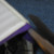 Use the scissors to snip the tape on the corners at the top and bottom of the binder. Fold it over. Repeat for the other inside cover. Use the scissors to snip the tape on the corners at the top and bottom of the binder. Fold it over. Repeat for the other inside cover.