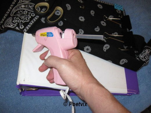 When you pull the bandanna back down to adhere to the glue, pull it tight and hold it for a minute. Add clips to the side to hold what you have glued in place as you continue applying hot glue down the cover. For smaller children, use white glue and 