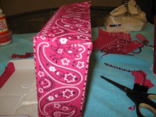 Make a slit and trim the bandanna to keep the hole in the back accessible. Make a slit and trim the bandanna to keep the hole in the back accessible.