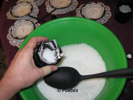 Hold the napkin lined can over the bowl of salt and carefully spoon salt into the can.