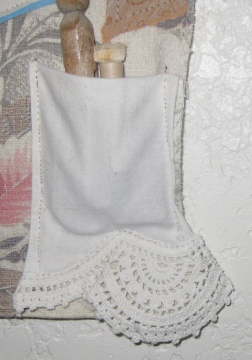 I used the edge of an old pillowcase (the pillowcase has threadbare but the lace at the edge was great) and sewed it to some old curtain fabric. The lace made a nice pocket to store other vintage items, like a peg clothespin and smelling salts.