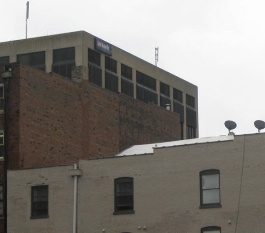 Ghost sign on brick building, can't read what it says. Black on brown.