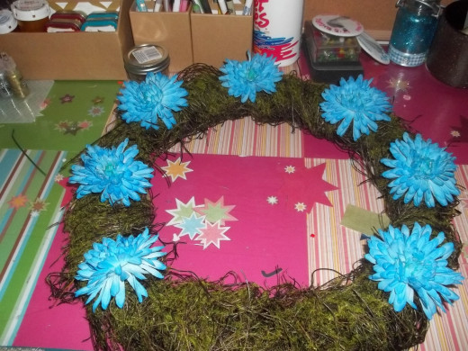 Larger flowers should be placed first equally around the wreath form
