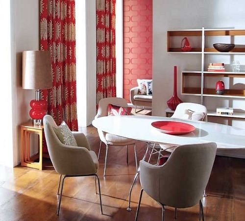 Notice how effectively the inclusion of the bold and bright orange-red draperies, accent wallcovering and other red accessories play off the rest of the neutral room?  By keeping the color scheme simple, the pop of color is not overpowering, but serv