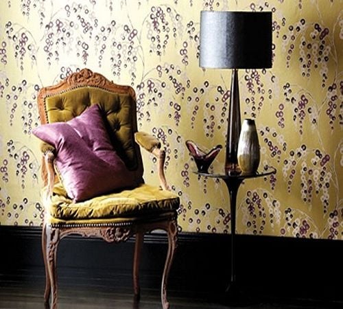 An archive-inspired Art Deco wallcovering from Harlequin, pattern 'Iola'. Notice the ebony base trim and flooring, as well as the modern black side chair and sleek table lamp with drum shade.  Go ahead and mix in a traditional button-tufted, velvet-u