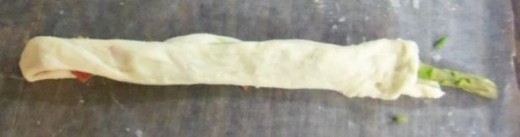 Pull remaining breadstick with the cheese &amp; bacon over top spiral wrapped part. Seal with fingers. If any pieces fall out, just push them back in.
