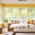 Sunrooms &amp; porches look bright with yellow accents.  Oversized rattan sofa &amp; baskets add a sense of down home to the room.