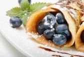 Stuffed blueberry pancakes with powdered sugar.