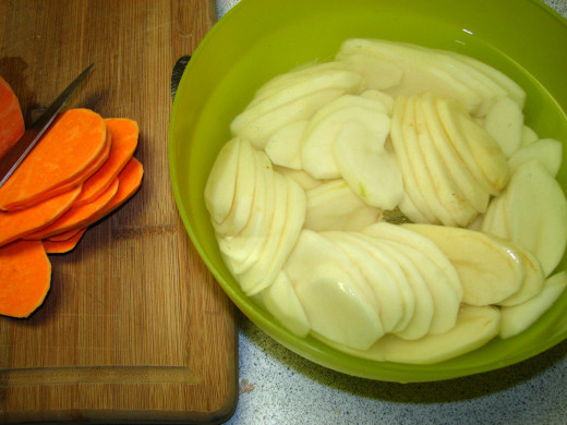 Slice the potatoes, keeping the white potatoes in salt water to prevent blackening.