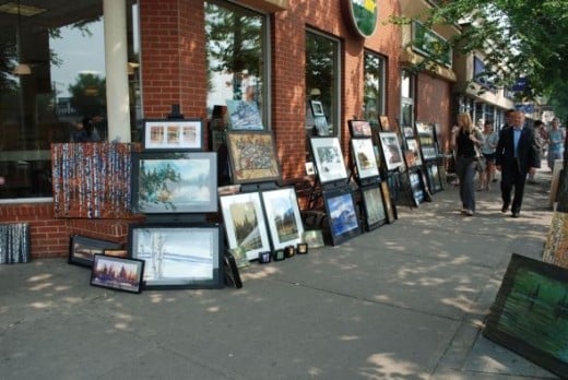 Pedestrians enjoying the work of several artists along Whyte Ave.